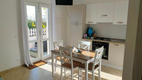 uma cozinha com uma mesa e cadeiras de madeira e uma cozinha com uma janela em Villa Chimera em Pachino