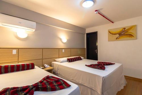 a hotel room with two beds with towels on them at Hotel Nacional Inn Curitiba Estação Shopping in Curitiba