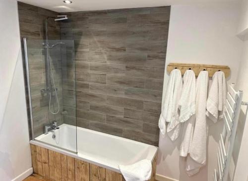 ein Bad mit einer Badewanne und einer Dusche mit Handtüchern in der Unterkunft The White Hart in Widworthy