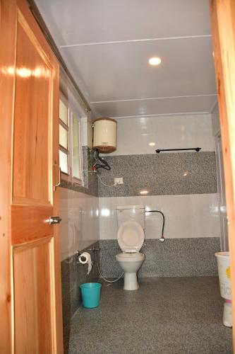 a bathroom with a toilet and a sink at Guruchhaya hotel and cottages in Manāli