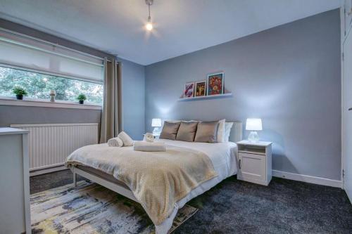 een slaapkamer met een groot bed en een raam bij Ravenscroft - Coorie Doon in Irvine