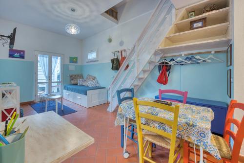 ein Wohnzimmer mit einem Esstisch und einer Treppe in der Unterkunft Casa Celeste - Goelba in Pomonte