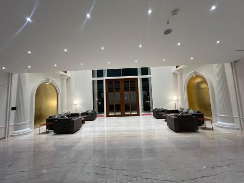 een lobby met banken en tafels in een gebouw bij Pride Resort, Rajkot in Rajkot