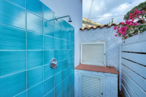 eine blau geflieste Dusche mit blauer Wand in der Unterkunft Casa Celeste - Goelba in Pomonte