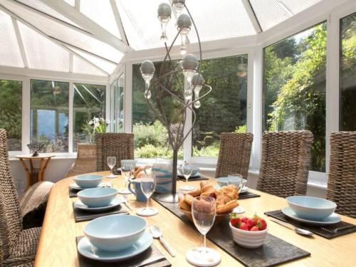 ein Esszimmer mit einem Tisch mit Essen drauf in der Unterkunft Coastal Cottage with Stunning Views Pass the Keys in Llanddona