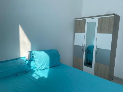 een blauwe slaapkamer met een bed en een spiegel bij Jasmine 37 House 