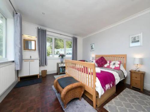 ein Schlafzimmer mit einem Bett und einem großen Fenster in der Unterkunft Coastal Cottage with Stunning Views Pass the Keys in Llanddona