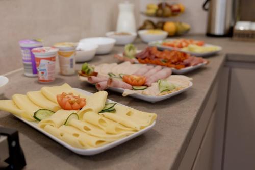 a table with plates of food on a counter at Bubble Hotel és Rendezvényközpont in Zalaegerszeg