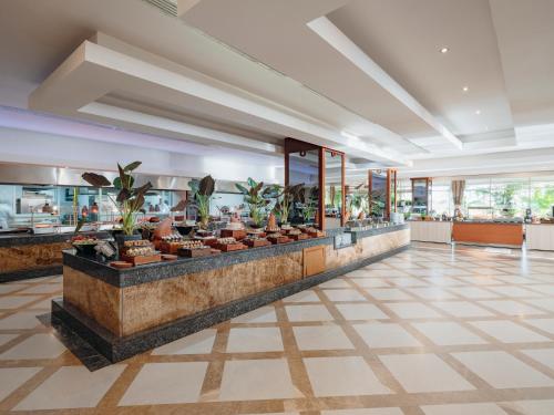 a lobby with a counter with potted plants at Selectum For Two Side in Kizilagac