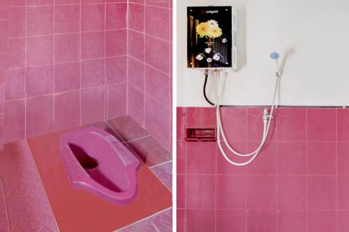 a pink bathroom with a shower with a purple toilet at OYO 90543 An-nur Guest House Syariah in Kuningan