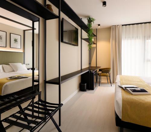 a hotel room with two beds and a desk at Nuvō Hotel Boutique in Oviedo