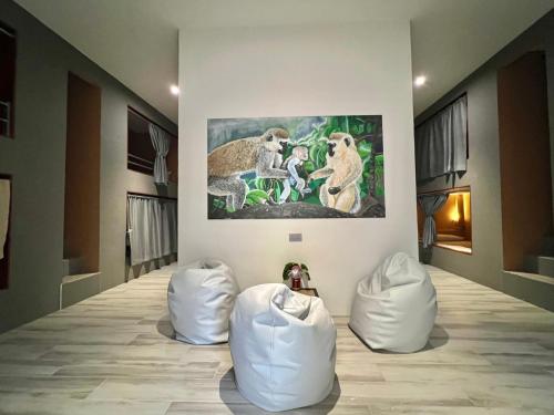 una habitación con sillas blancas y una pintura en la pared en Beach Jungle, en Ko Chang