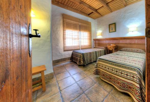 1 dormitorio con 2 camas y ventana en Hacienda los Majadales, en Conil de la Frontera