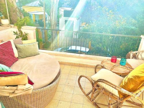 a balcony with a table and chairs on a porch at כפר בלב העיר ליד הים המיקום המושלם בתל אביב in Tel Aviv