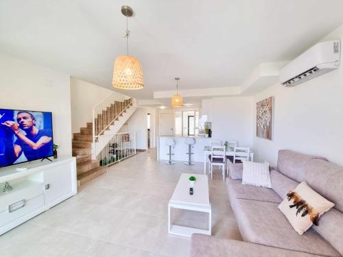 a living room with a couch and a tv at Sea Views Villa Benalmádena ComoTuCasa in Benalmádena