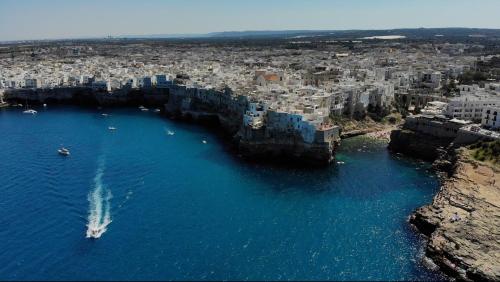 an aerial view of a city with blue water and buildings at L'ARTE DI VENERE SUITE in Polignano a Mare