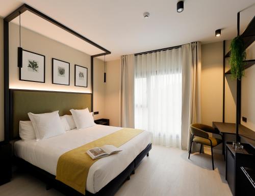 una camera d'albergo con un grande letto e una finestra di Nuvō Hotel Boutique a Oviedo