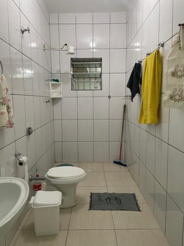 a bathroom with a toilet and a sink at Paraíso Particular in Itanhaém