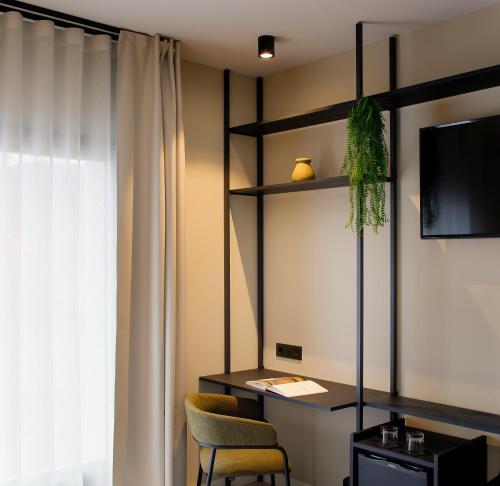 a room with a desk and a chair and a television at Nuvō Hotel Boutique in Oviedo