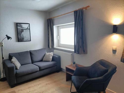 a living room with a couch and a chair and a window at Pension & Ferienwohnungen Haus Edelweiß in Holzgau