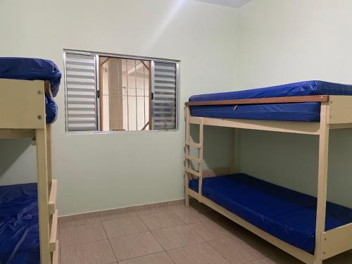 two bunk beds in a room with a window at Paraíso Particular in Itanhaém