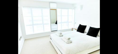 een slaapkamer met een wit bed en 2 handdoeken bij Stylish warehouse- central Brighton in Brighton & Hove