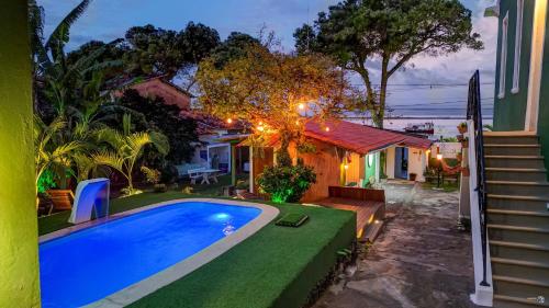 a backyard with a swimming pool and a house at Vila Casarão Verde in Itacaré