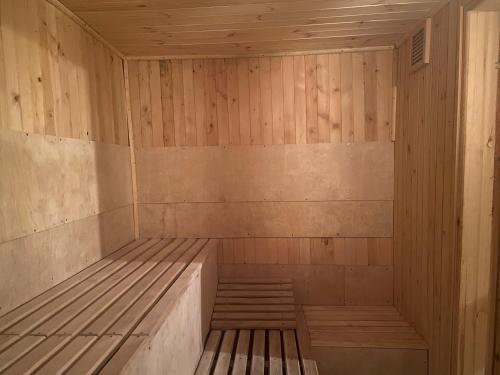 a wooden sauna with a wooden floor and stairs at Zbychówka in Kolonia Rybacka