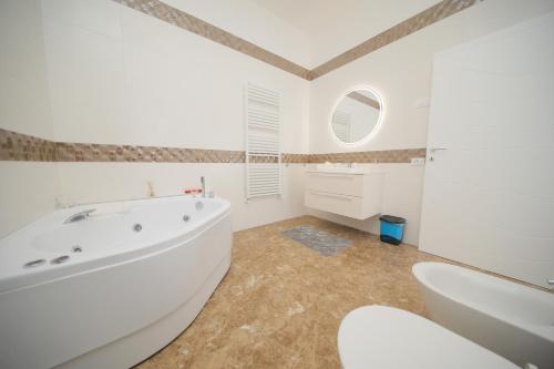 a white bathroom with a tub and a sink at L'ARTE DI VENERE SUITE in Polignano a Mare