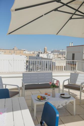 a balcony with chairs and a table with a plate of food at L'ARTE DI VENERE SUITE in Polignano a Mare