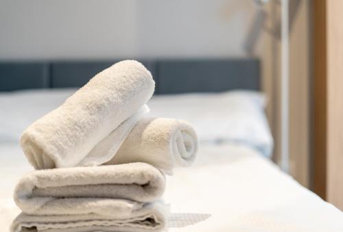 una pila de toallas sentadas encima de una cama en Cracow Luxury Apartment #6, en Cracovia