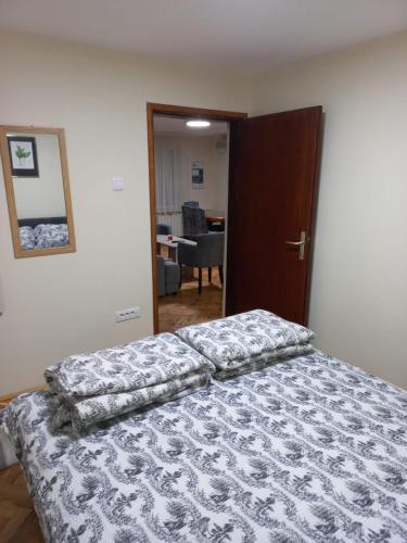 a bedroom with a bed and a door to a office at Green Garden Apartments in Surčin