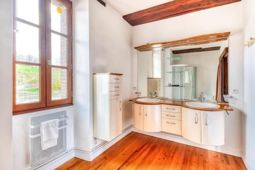 ein Badezimmer mit zwei Waschbecken und einem großen Fenster in der Unterkunft Moulin de Neuville in Saint-Germain-de lʼHomel
