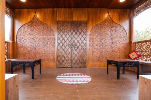 a room with two tables and a door with a rug at Ekta Houseboat Statue Of Unity Kevadia in Vadodara