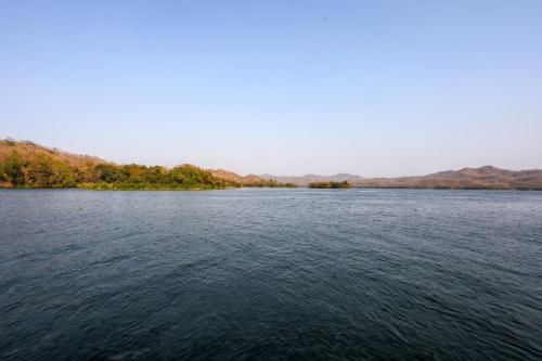 a large body of water with trees in the background at Ekta Houseboat Statue Of Unity Kevadia in Vadodara