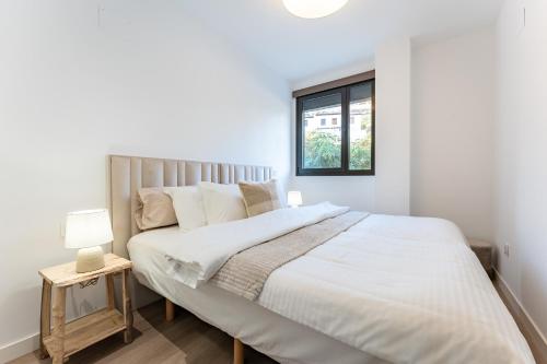 Un dormitorio blanco con una cama grande y una ventana. en 215 Navi Golf, en La Cala de Mijas