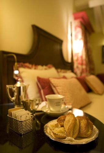 a table with a plate of bread and a cup of coffee at Santa Maria Novella - WTB Hotels in Florence