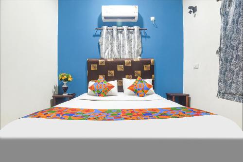 um quarto com uma cama com uma parede azul em FabHotel IRAA Resort With Pool em Baga