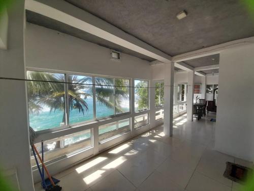 an empty room with a view of the ocean through windows at SEASHORE Resort & Villa in Talpe