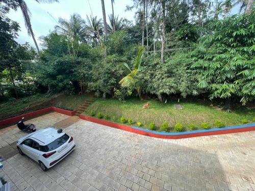 a white car parked in a parking lot at Silver Oak By Exuberance Stays (Independent Holiday Home) in Wayanad