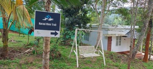 a sign in front of a house with a chair at Silver Oak By Exuberance Stays (Independent Holiday Home) in Wayanad