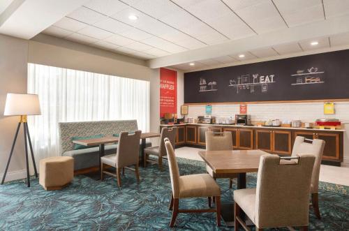 a restaurant with tables and chairs and a counter at Hampton Inn Pembroke Pines in Pembroke Pines