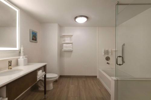 a bathroom with a shower and a toilet and a sink at Hampton Inn Pembroke Pines in Pembroke Pines