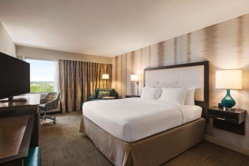 a hotel room with a large bed and a desk at Hampton Inn Pembroke Pines in Pembroke Pines