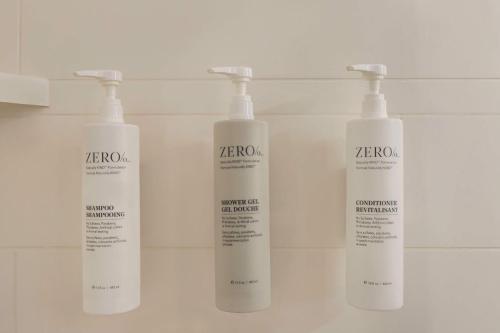 three white shampoo bottles on a shelf in a bathroom at Hampton Inn Pembroke Pines in Pembroke Pines