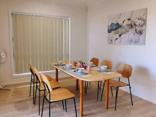 a dining room with a wooden table and chairs at MaraylyaBox hillGables Specious 5Br Sweet House in Pitt Town