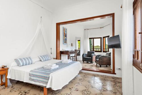 a bedroom with a bed and a mirror at Villa Son Prats in Cala Santandria