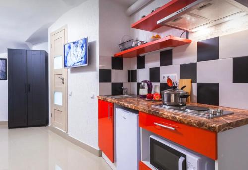 een keuken met rode en zwarte en witte tegels bij VIP apart 647 in Tbilisi City