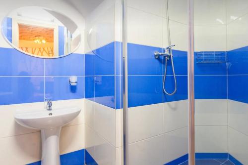 een blauwe en witte badkamer met een wastafel en een douche bij VIP apart 647 in Tbilisi City
