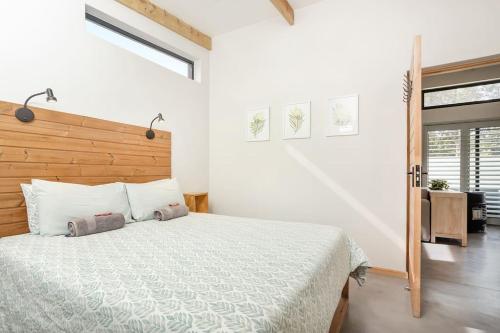 una camera da letto con un letto grande con testiera in legno di Mountain and Sea Cottage a Hermanus